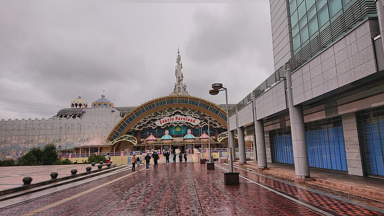 The entrance and exterior of Sanrio Puroland viewed from a wet walkway